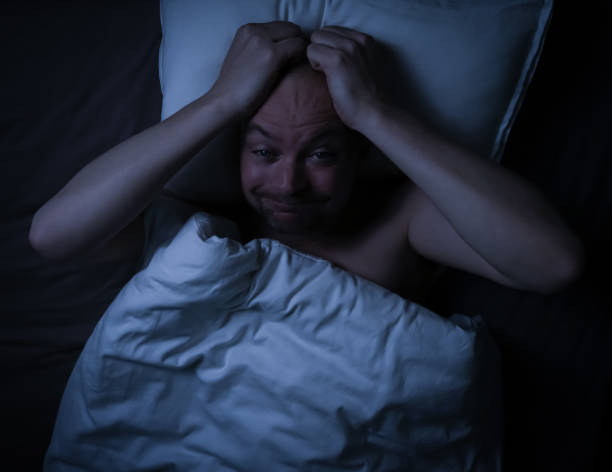 istock Man in bed cant sleep staring at the ceiling. 1301200218