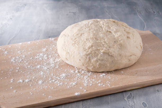 istock Fresh dough ready for baking bread or pizza on wooden board. 1301204718