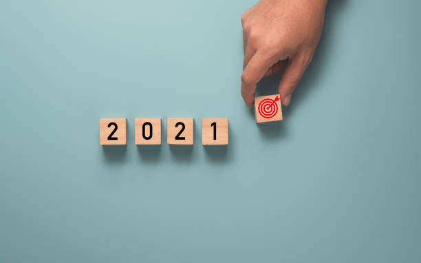 istock Businessman holding target which print screen on wooden cube block with 2021 year , Setup business target concept. 1301207292