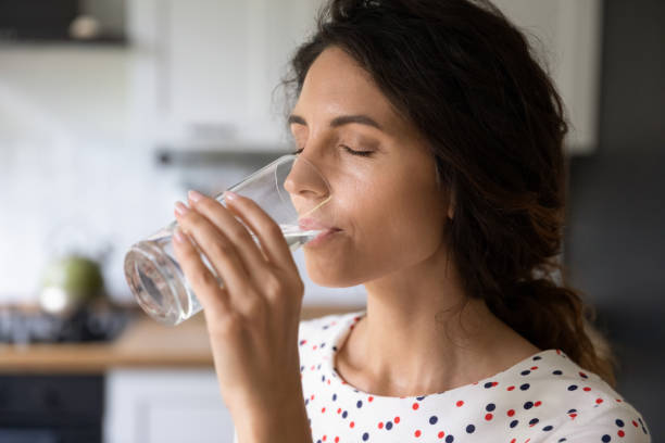 istock Thirsty young woman drink water from glass 1301207796