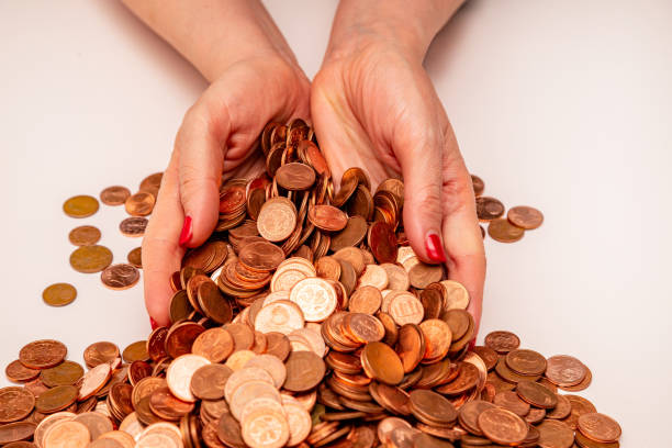istock Female hands holding many small euro coins on white background 1301207942