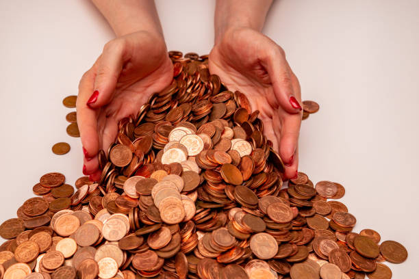 istock Female hands holding many small euro coins on white background 1301207945