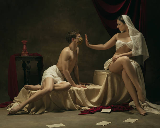 istock Modern remake of classical artwork with coronavirus theme - young medieval couple on dark background 1301209083