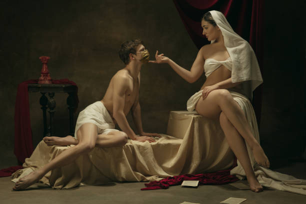 istock Modern remake of classical artwork with coronavirus theme - young medieval couple on dark background 1301209097