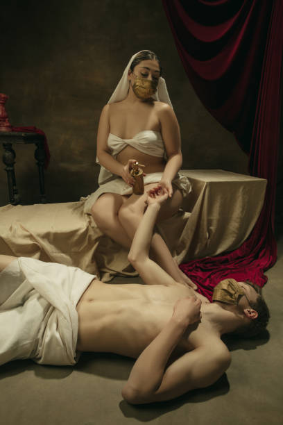 istock Modern remake of classical artwork with coronavirus theme - young medieval couple on dark background 1301209103