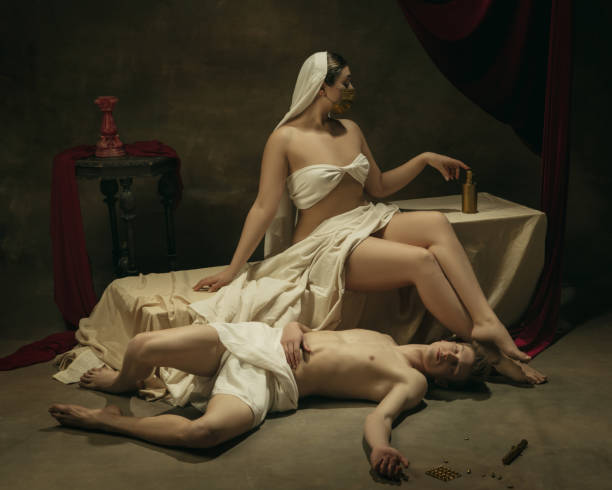 istock Modern remake of classical artwork with coronavirus theme - young medieval couple on dark background 1301209105