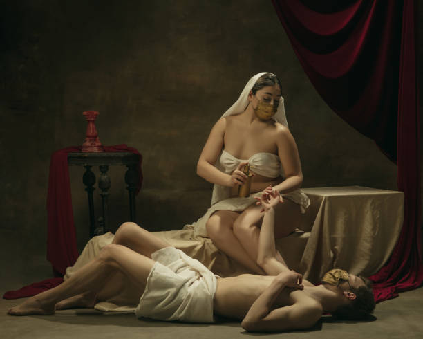 istock Modern remake of classical artwork with coronavirus theme - young medieval couple on dark background 1301209121