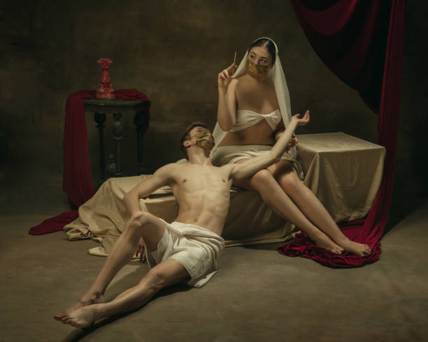 istock Modern remake of classical artwork with coronavirus theme - young medieval couple on dark background 1301209170