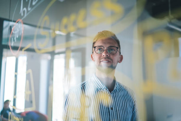 istock Thoughtful blonde male designer in eyewear looking at sketches and drawings analyzing information for making solutions, confident man entrepreneur in smart casual look pondering on planning strategy 1301209972