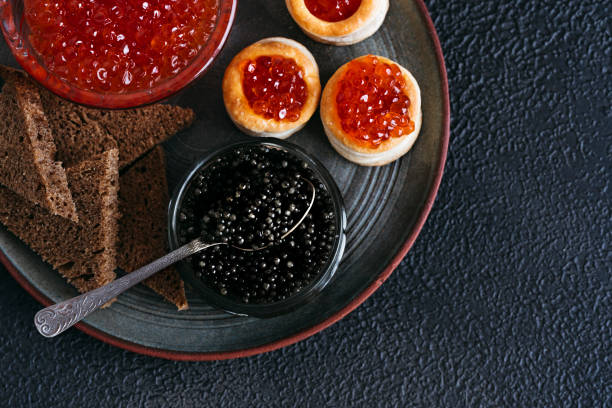 黒と赤の魚のキャビアは黒の背景に提供されます。 - caviar salmon red gourmet ストックフォトと画像