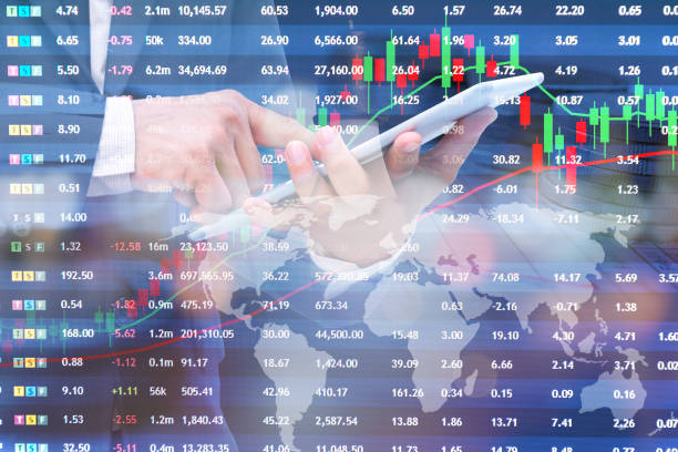 istock Businessman using a tablet double with and financial graph on finance documents, stacked coins 1301225377