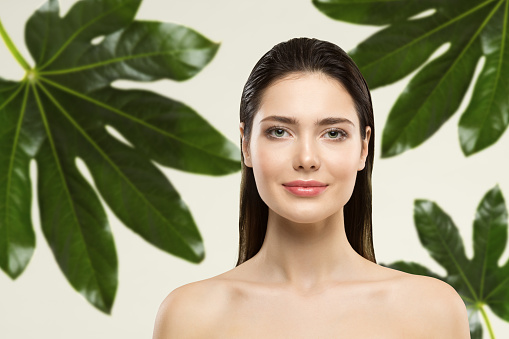 Woman Beauty Face Natural Make up. Green Leaf Cosmetic Skin Care and Hair Treatment. Wet Hair Perfect Model in Tropical Leaves Nature Background