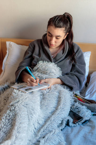 istock Young woman emphasizing a book in bed to study. 1301230890
