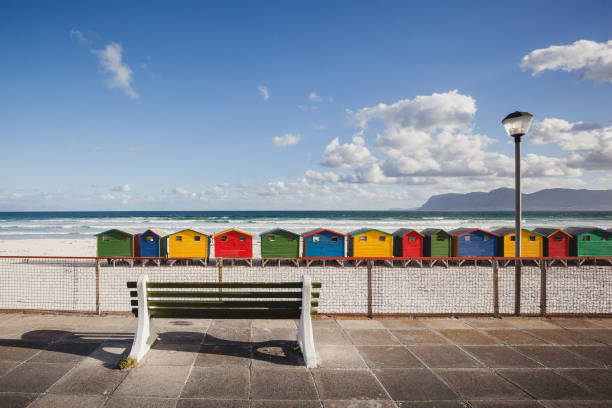 Bench overlooking colorful beach cabins in Kalk Bay, South Africa stock photo