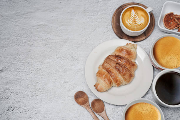 istock cup of coffee and Fresh baked croissant on white kitchen table. Top view with copyspace for your text. 1301234451