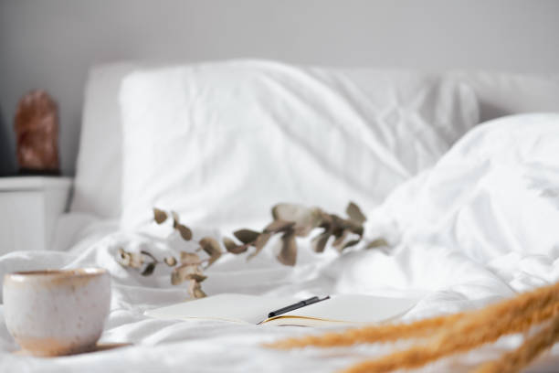 istock Open notepad with blank pages in textile white background, dried flowers and cup of tea. 1301234642