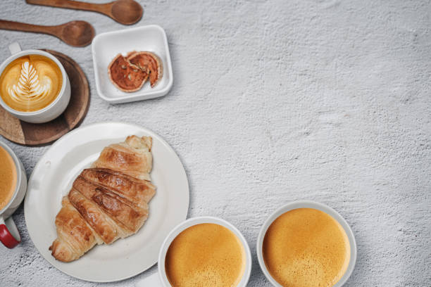 istock cup of coffee and Fresh baked croissant on white kitchen table. Top view with copyspace for your text. 1301234924