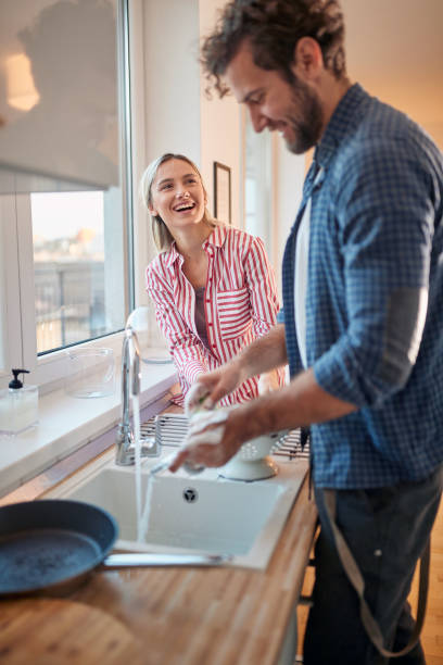 istock A young couple having a good time doing housework in the kitchen together. Kitchen, housework, home, relationship 1301236560