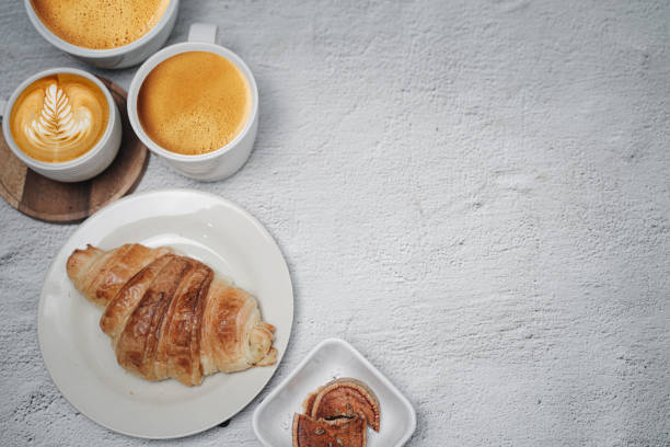 istock cup of coffee and Fresh baked croissant on white kitchen table. Top view with copyspace for your text. 1301236746