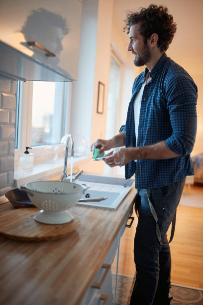 istock Young man enjoying doing housework in the kitchen. Kitchen, housework, quarantin, home 1301237457