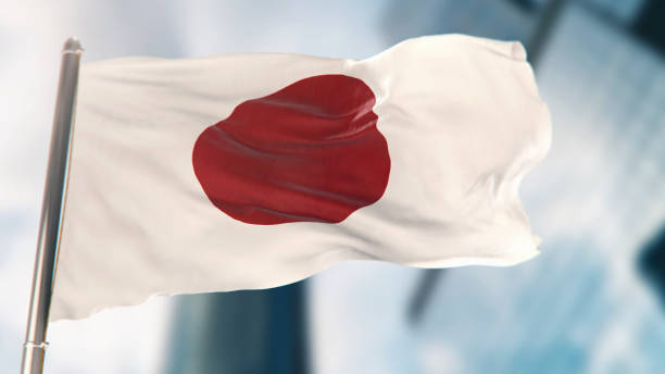 bandera nacional de japón contra edificios desenfocados de la ciudad - japanese flag fotos fotografías e imágenes de stock
