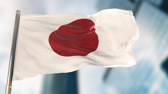 National Flag of Japan Against Defocused City Buildings