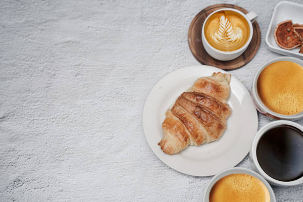 istock cup of coffee and Fresh baked croissant on white kitchen table. Top view with copyspace for your text. 1301240086