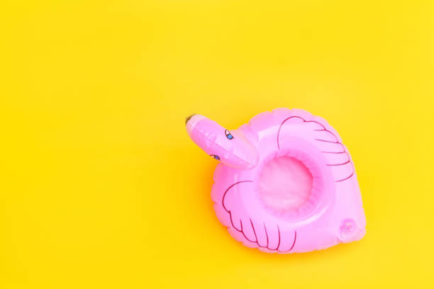 istock Summer beach composition. Simply minimal design with pink Inflatable flamingo isolated on yellow background. Pool float party, trendy celebrity fashion concept. Flat lay top view copy space 1301241276