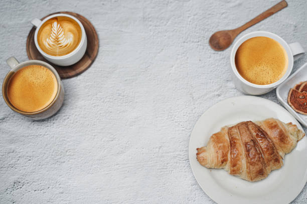 istock cup of coffee and Fresh baked croissant on white kitchen table. Top view with copyspace for your text. 1301241370