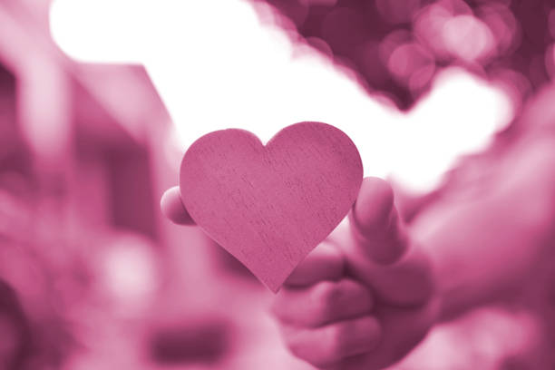 Valentine's day concept background with hearts on hand.Calligraphy words text sign on copy space.