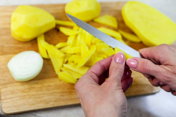 istock Female hands slicing potatoes for frying, cooking dinner, top view 1301243798