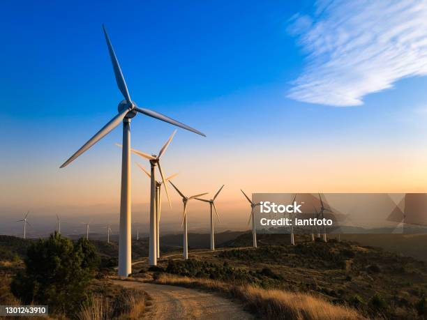 Wind Farm At Sunset Stock Photo - Download Image Now - Wind Turbine, Fuel and Power Generation, Renewable Energy