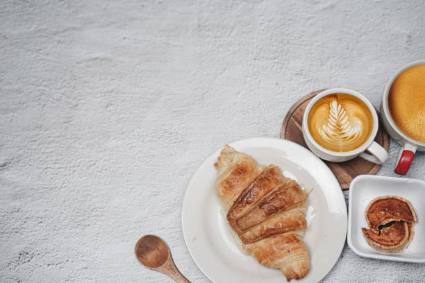 istock cup of coffee and Fresh baked croissant on white kitchen table. Top view with copyspace for your text. 1301244020