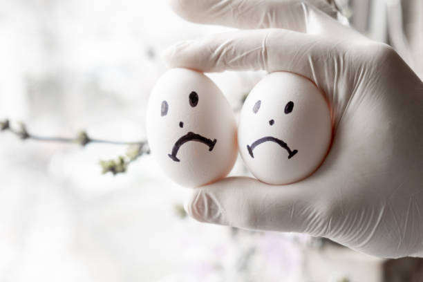 Urology concept. Male problems, infertility, decreased testosterone. Chicken eggs in hand with sad emoticons. Urology concept. Male problems, infertility, decreased testosterone. Chicken eggs in hand with sad emoticons. testis stock pictures, royalty-free photos & images