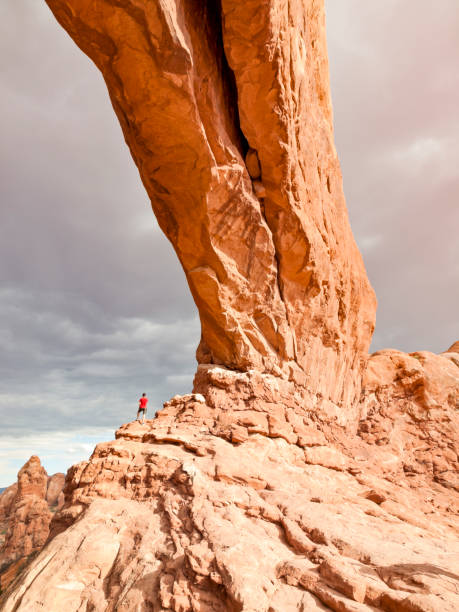 istock Hiker under Rock Arch, Arches National Park 1301244927
