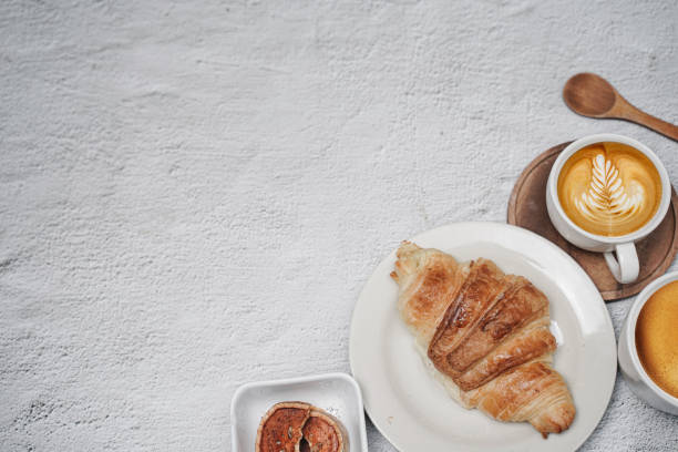 istock cup of coffee and Fresh baked croissant on white kitchen table. Top view with copyspace for your text. 1301245823