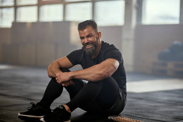 istock Man smiling after a battle rope workout 1301248782