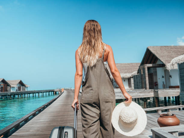 istock Woman pulls trolley on wooden pier in tropical destination 1301248974