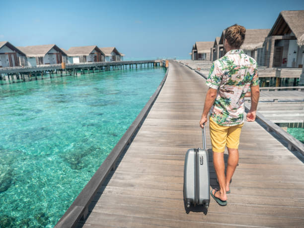 istock Man pulls trolley on wooden pier in tropical destination 1301249119