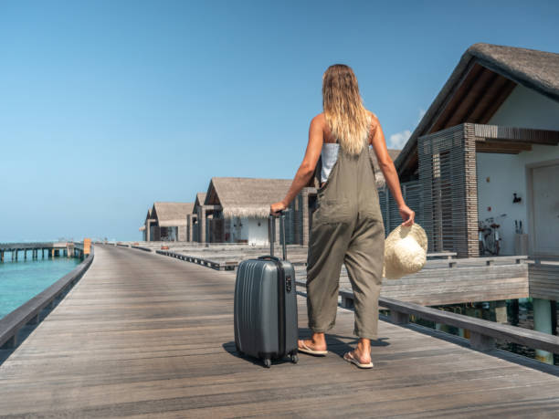 istock Woman pulls trolley on wooden pier in tropical destination 1301249410