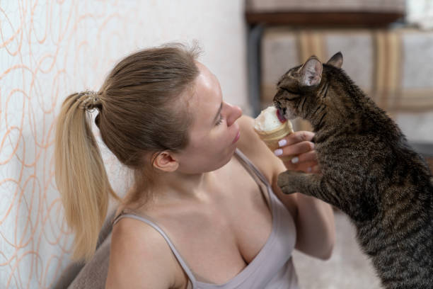 istock young woman eats ice cream and shares with kitty 1301250746