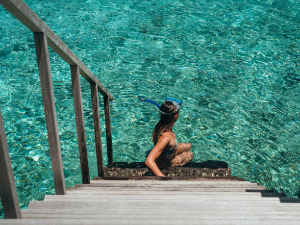 istock Woman sits on villa stairs after snorkelling 1301250888