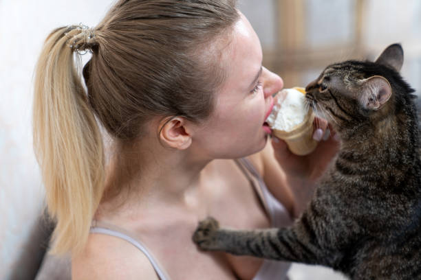 istock young woman eats ice cream and shares with kitty 1301250952