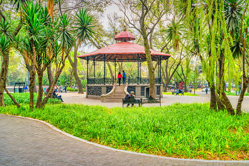 People relax in Chapultepec Park in downtown Mexico City, Mexico on a cloudy day. Bosque de Chapultepec contains many attractions like the Chapultepec Castle, the Chapultepec Zoo, the Museum of Anthropology, and the Rufino Tamayo Museum, among others.
