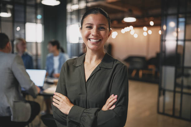 istock Confident young businesswoman smiling while standing in a modern office 1301252090