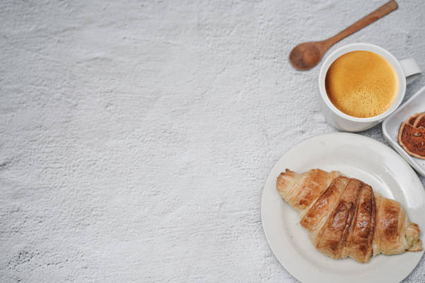 istock cup of coffee and Fresh baked croissant on white kitchen table. Top view with copyspace for your text. 1301252343