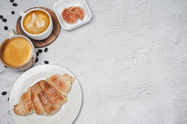 istock cup of coffee and Fresh baked croissant on white kitchen table. Top view with copyspace for your text. 1301252611