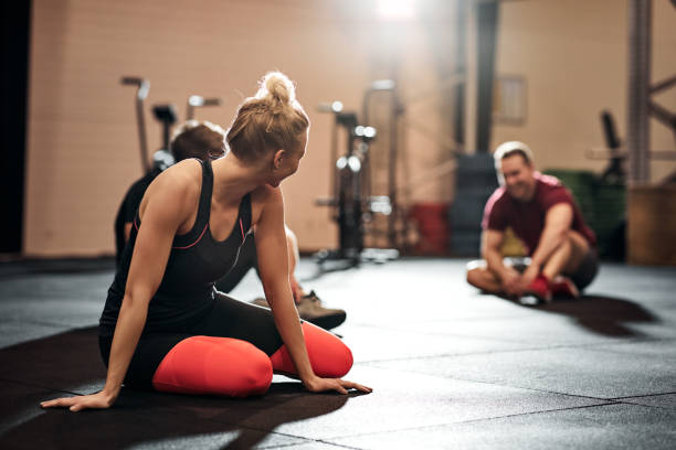 istock Fit people sitting on a gym floor after working out 1301252670