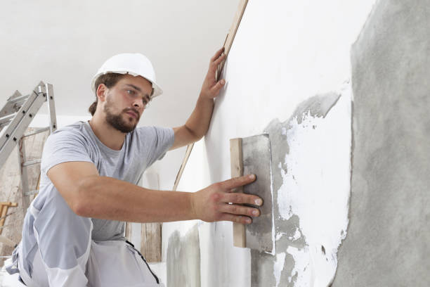istock Hands man plasterer construction worker at work with trowel, plastering a wall, closeup 1301252684