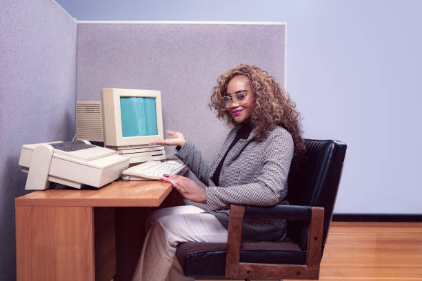 Retro Office Worker At Cubicle Computer Workstation A portrait of a vintage African American business woman in retro style, working at a cubicle computer desk.  1980's - 1990's fashion style. 1980 photos stock pictures, royalty-free photos & images